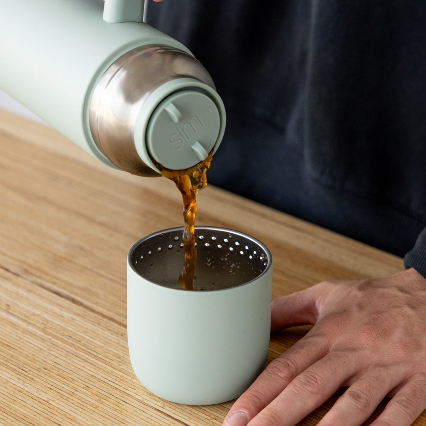 Roam sage green thermos bottle with matching drinking cup on white background